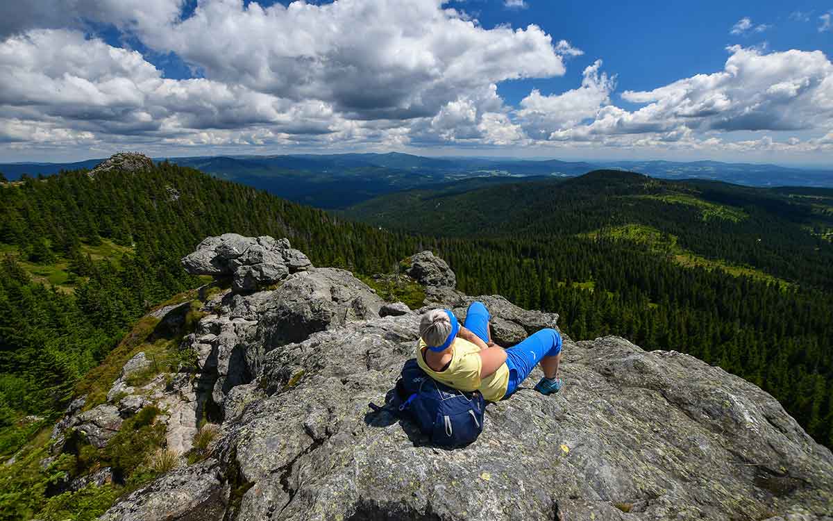 Wanderer genießt den Ausblick auf den Bayerischen Wald vom Silberberg, in der Nähe des Wellnesshotels Waldeck.