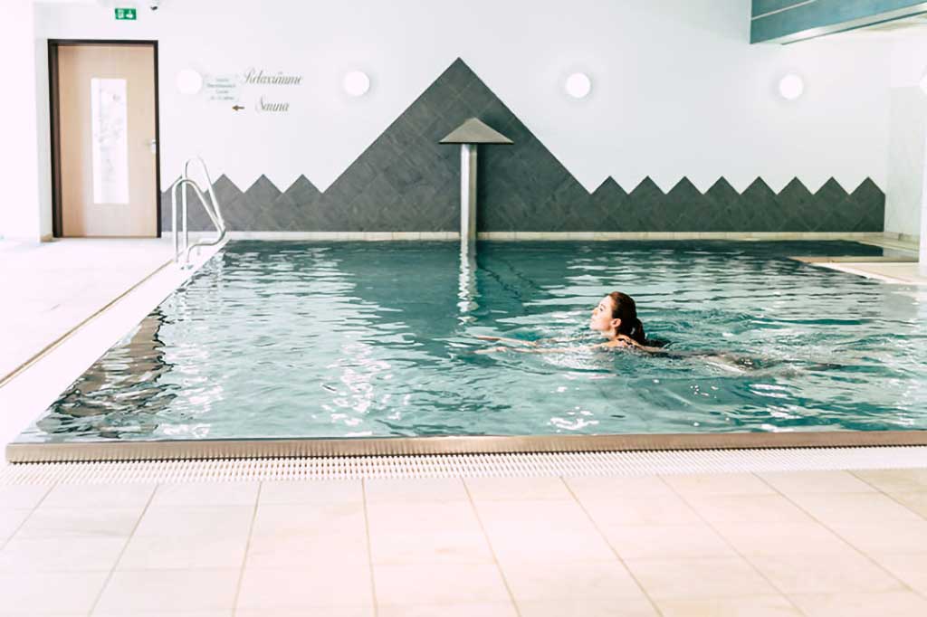 Frau schwimmt eine Runde im Erlebnisbad des Wellnesshotels Waldeck im Bayerischen Wald.