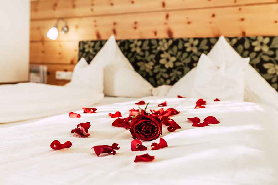 Rosenblüten dekorativ auf einem Bett im Wellnesshotel Waldeck im Bayerischen Wald.