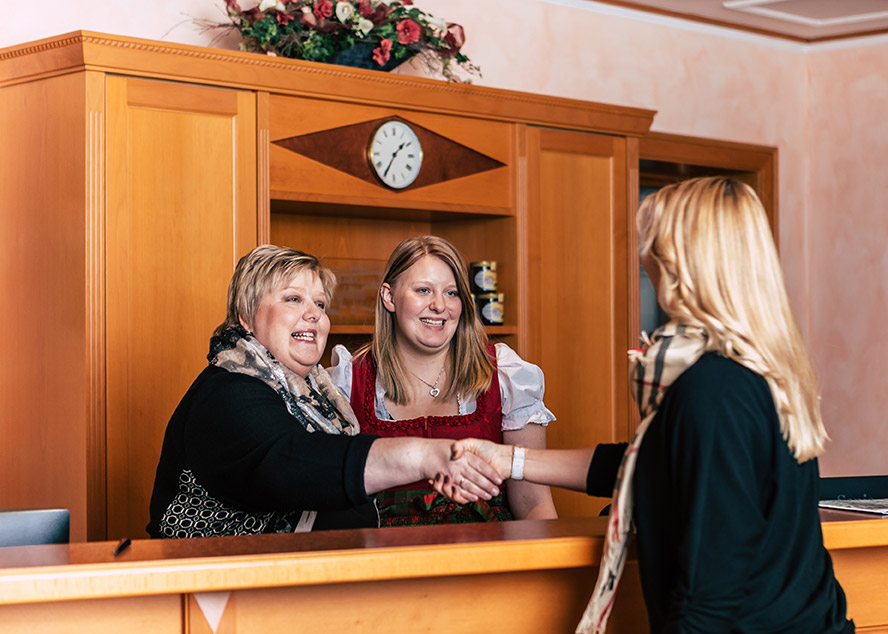 Zufriedener Gast wird an der Rezeption des Wellnesshotels Waldeck im Bayerischen Wald herzlich empfangen