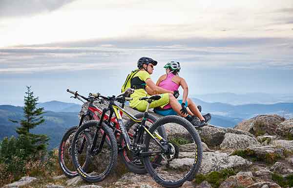 Paar macht Pause während einer E-Bike Tour im Bayerischen Wald, Bodenmais, mit Mountainbikes
