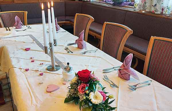 Hochzeitsfeier im Bayerischen Wald – Tisch mit romantischen Kerzen und Blumenschmuck im Wellnesshotel Waldeck Bodenmais