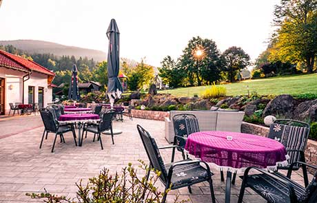 Sonnige Terrasse im Wellnesshotel Waldeck in Bodenmais mit gemütlichen Sitzmöbeln.